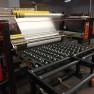 Industrial Laminator Walco 822 - close-up of the film unwind station and protective film being fed through the application rollers